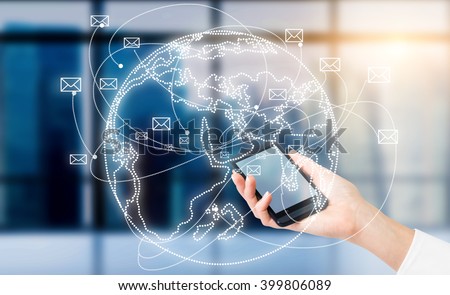 Hand with smartphone, globe with envelopes flying around over it. Window at background. Concept of communication. Royalty-Free Stock Photo #399806089