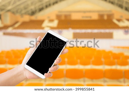 woman use mobile phone and blurred image of the auditorium