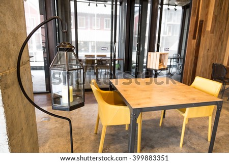 lantern glass and set of soft tan color wooden table in luxury restaurant loft style design Royalty-Free Stock Photo #399883351