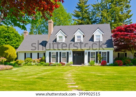 Custom built luxury house with nicely trimmed and landscaped front yard, lawn in a residential neighborhood. Vancouver Canada. Royalty-Free Stock Photo #399902515