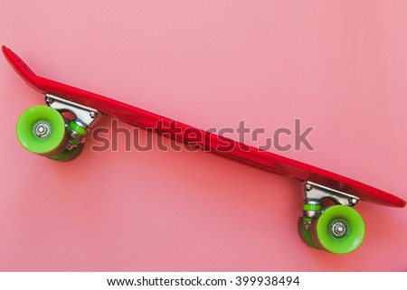 Red Skateboard on pink background. Flat lay fashion set.