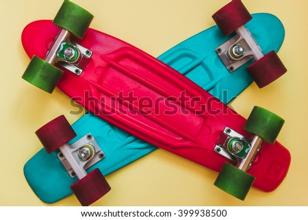 Red and Blue Skateboards on yellow background. Flat lay fashion set.