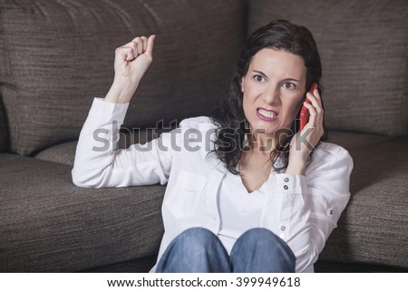 Angry woman shouting on the phone. Toned image with shallow depth of field