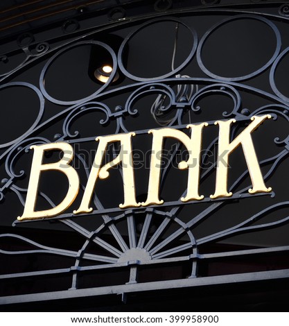 Old fashioned bank sign with ornamental wrought iron and golden letters. Building exterior of a bank. Finance symbol. 