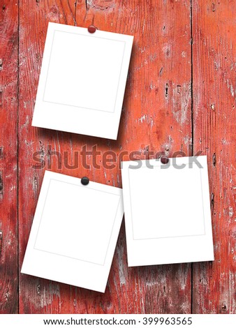 Close-up of three blank square instant photo frames with pins on weathered wood