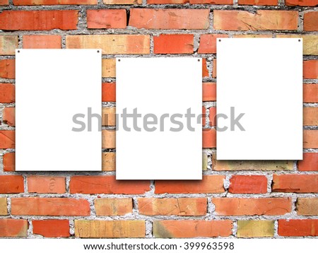 Close-up of three nailed blank frames on orange brick wall background