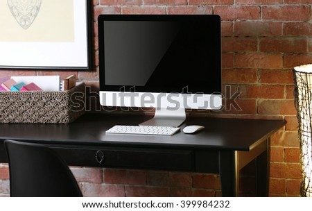 Stylish working place with computer and wooden table.