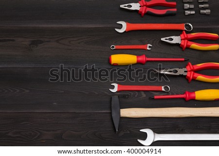 Industrial background. Set of tools for construction and repair on black wooden table. Photo has copy space. Top view (view from above)