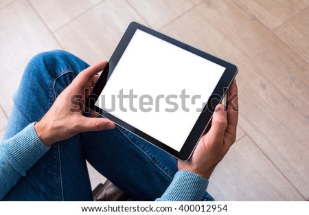 Man using tablet computer while sitting on a wooden floor. View from above. Clipping path included. Royalty-Free Stock Photo #400012954