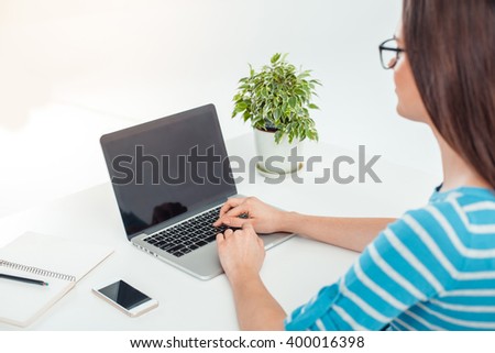 Close up photo of business woman in modern office. Woman working with laptop. Focus on laptop