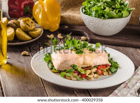 Salmon with hollandaise sauce and fresh salad with roasted walnuts
