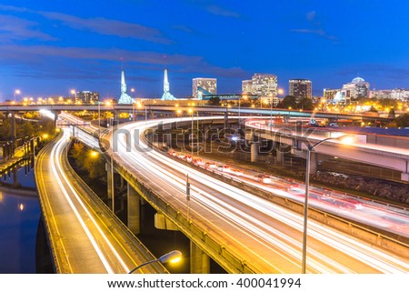 traffic on road with cityscape and skyline of portland at twilight