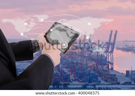 hand presses on world map with digital tablet,Industrial Container Cargo freight ship at dusk for Logistic Import Export background (Elements of this image furnished by NASA)