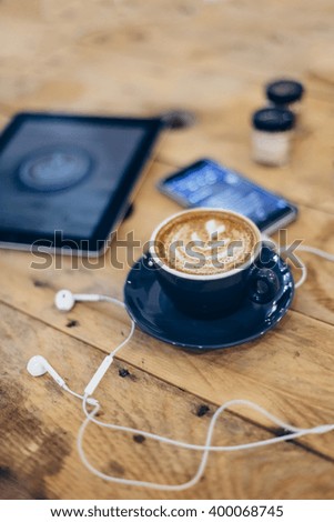 Cappuccino Digital Tablet and Mobile Phone on a Table with Head Phones