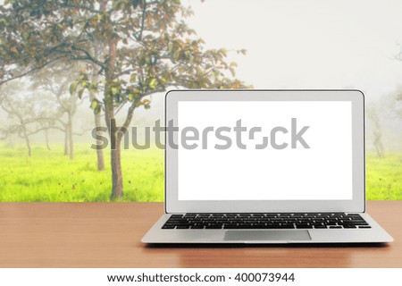 blank screen laptop on table with blur wild background