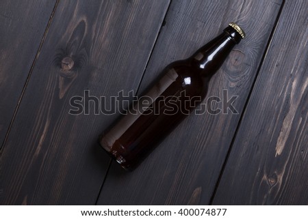 Bottle of beer on a dark wooden surface Royalty-Free Stock Photo #400074877