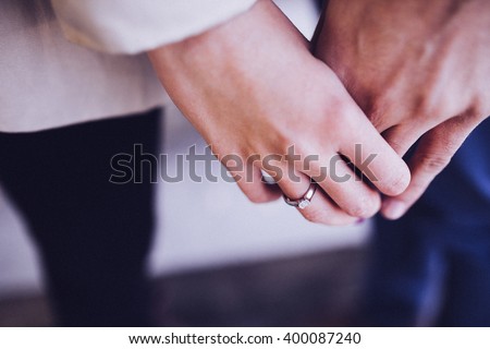 A couple holding hands. Closeup Royalty-Free Stock Photo #400087240
