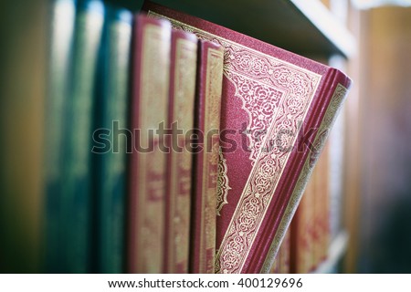 A book is selected from bookshelf in public library with vintage filter blur background Royalty-Free Stock Photo #400129696