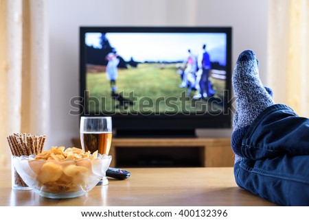 Television, TV watching (golf game) in living room with feet on table - stock photo