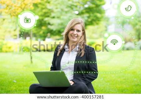 Young businesswoman using tablet, laptop in the park