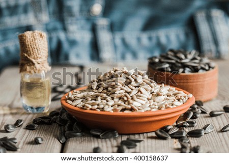 Fresh Sunflower seed and oil. Shelled sunflower seeds in wood bowl. 
Sunflower close-up