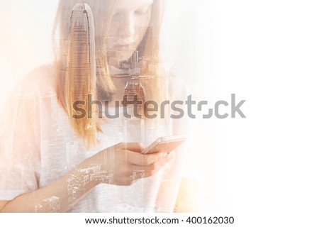 Closeup photo of stylish teenager girl wearing blank t-shirt and looking cell phone. Double exposure, panoramic view contemporary megalopolis background. Space for your business message. 