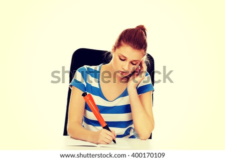 Pensive teenage woman doing homework