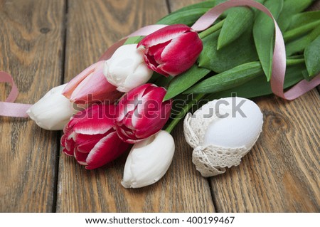 Colorful tulips with Easter egg on a wooden background