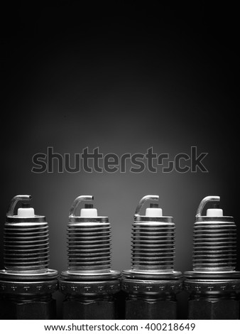 A set of new spark plugs of the car, and spare parts of vehicles on a dark  background. Studio macro image of high quality. To advertise auto service.