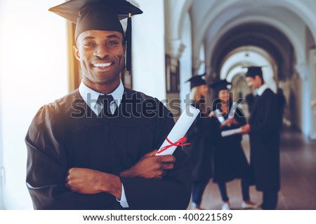 Happy graduate. Happy African man in graduation gowns holdin Royalty-Free Stock Photo #400221589