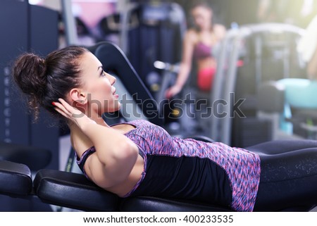 Picture of fit woman doing sit ups in gym