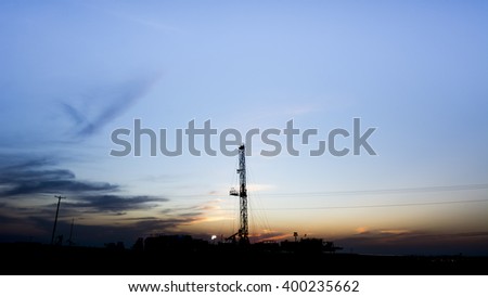 Sunset in the oil field - silhouette of crude oil rig - Bahrain