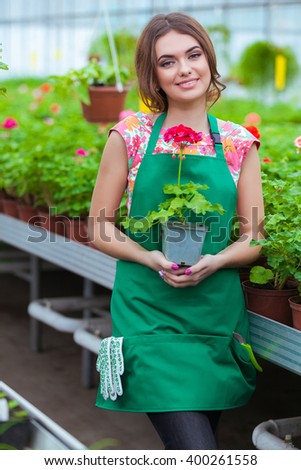Florists woman working with flowers at a greenhouse. Springtime