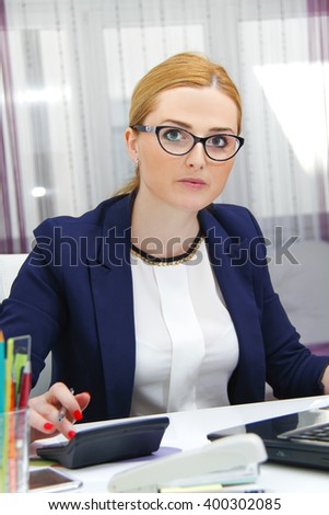 Photo of the Business woman analyzing investment charts with calculator and laptop