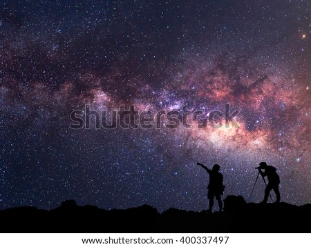 Star-catcher. A person is standing next to the Milky Way galaxy 