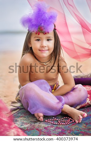 fairy tale portrait of smiling little eastern princess. Vertical photo.