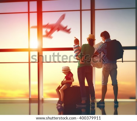 Happy family with suitcases in the airport.  Royalty-Free Stock Photo #400379911
