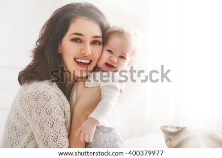 happy loving family. mother playing with her baby in the bedroom. Royalty-Free Stock Photo #400379977
