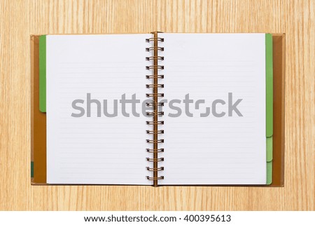 Open notebook with lined pages isolated on wood background