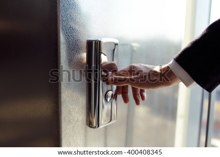 Man pressing elevator button. finger presses the elevator button. Red button. sunset light. businessman is a lift. high floor. hand reaches for the button of the elevator call.