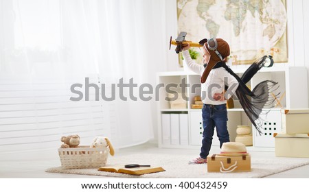 concept of  dreams and travels.  pilot aviator child with a toy airplane plays at home in his room Royalty-Free Stock Photo #400432459