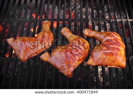 Three Crispy And Tasty BBQ Chicken  Quarters Roasted On The Hot Charcoal Flaming Grill, Closeup, Top View