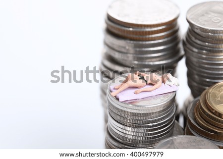 Miniature people on stack of coins
