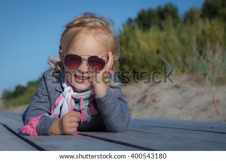Happy smiling little girl on beach vacation Royalty-Free Stock Photo #400543180