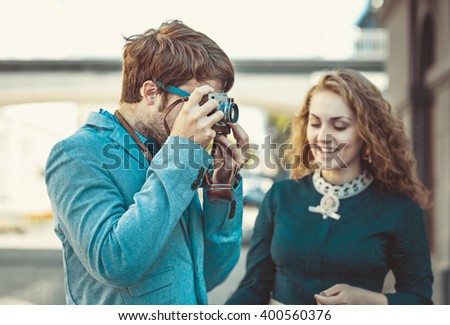 Hipster man wants to take a picture of a beautiful girl using your vintage camera