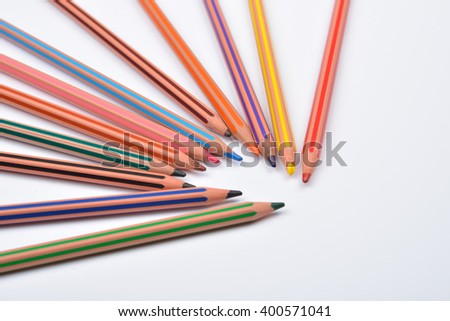 Close up picture of colored pencil crayons with stripes on white background. Assortment of colored pencils/ Colored drawing pencils. Selective focus