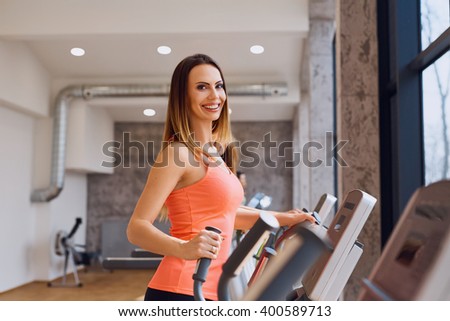 Happy young woman at gym doing cardio workout