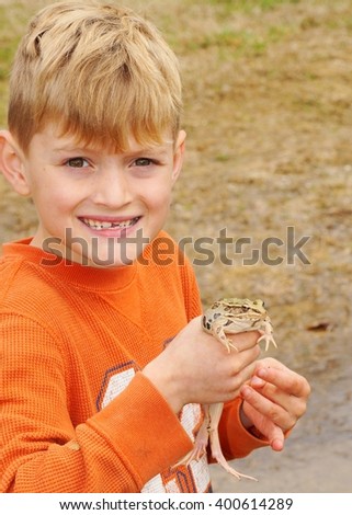 Happy boy holding a frog, Southern Leopard Frog, Lithobates sphenocephalus