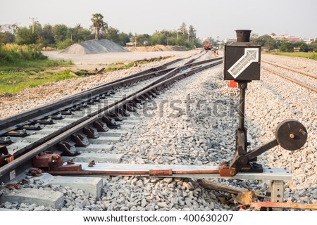 Hand-operated railroad switch with lever and signal.
