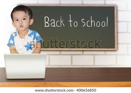 Cute little boy on a green background. Looking at camera. School concept